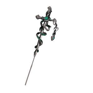 Macro shot of gothic sword hairpin with green snake detail and emerald gemstone
