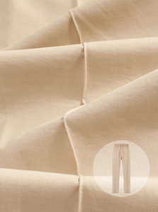 Primo piano dettagliato della trama del tessuto twill beige e delle cuciture dei pantaloni
