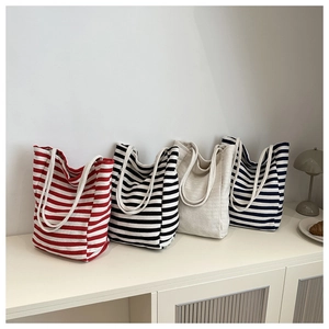 Detailed row of four minimalist canvas tote bags in striped and solid beige designs