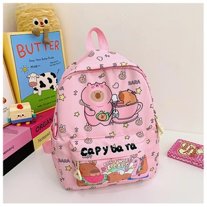 Pink kids backpack featuring cute capybara patterns next to colorful books