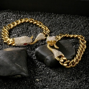Close-up of gold Cuban bracelets with luxury crystal-encrusted snake head clasps