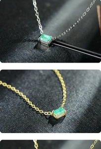 Macro shot of gold and silver necklaces with rectangular emerald green gemstone pendants