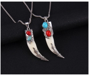 Detail of faux wolf tooth necklaces with turquoise inlay and silver metal accents