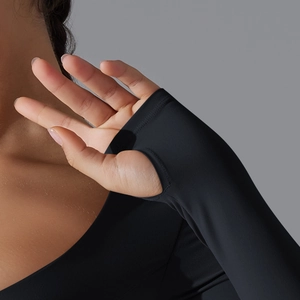 Dettaglio della maglia da yoga nera a maniche lunghe con pratico foro per il pollice sport
