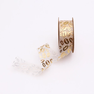 Detail of white organza ribbon with gold lip pattern for gift and floral wrapping