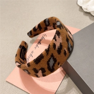 Close-up of leopard print plush headband with Hand Made label and soft knitted texture