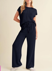 Close-up of women's ribbed knit two-piece set featuring short sleeve top and wide leg pants