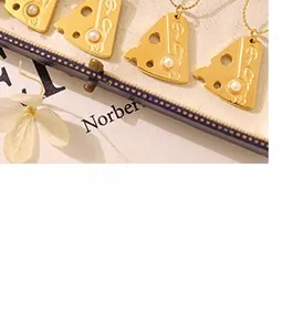 Detail of cheese shaped gold pendants with pearls on a 18k gold plated ball chain