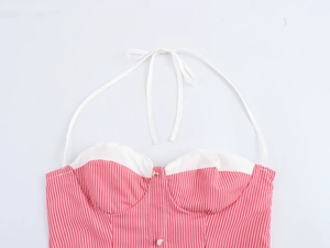 Detail view of red striped halter dress featuring white lace trim and front buttons