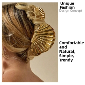 Detailed view of elegant shell-shaped golden metal hair claws for French style hairstyles