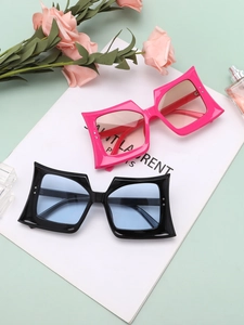 Detail view of oversized geometric sunglasses in fuchsia and black with gradient lenses