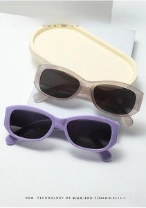 Macro view of purple and translucent champagne rectangle sunglasses with dark gray lenses