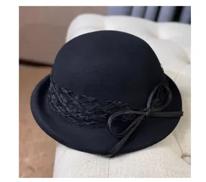 Detail of elegant black wool felt dome hat with intricate lace trim and bow accent