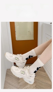 Detailansicht weißer Socken mit schwarzem Katzenmuster kombiniert mit Retro-Sneakern