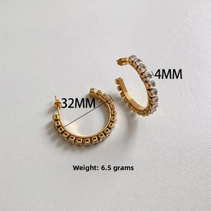 Gros plan de boucles d'oreilles C dorées avec zircon montrant un diamètre de 32mm