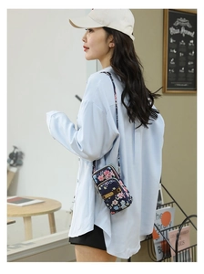 Detail of floral nylon mini crossbody bag with three zipper compartments and shoulder strap