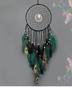 Detail of dream catcher featuring peacock feathers and green beads with tree charm