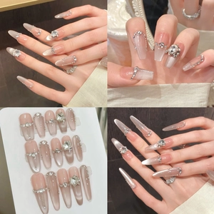 Detailed macro view of nude pink cat-eye press-on nails with silver rhinestones and bows