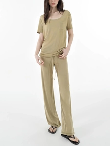 Detailed view of the olive green drawstring waistband and smooth fabric texture on pants