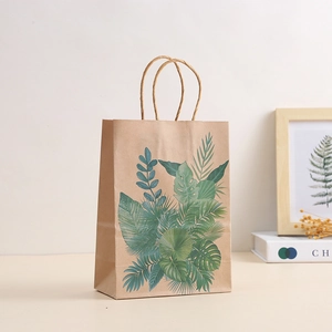 Eco-friendly brown kraft paper gift bag with tropical green leaf patterns and twisted rope handle