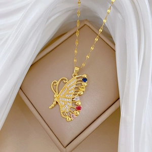 Detail shot of golden butterfly pendant with multi-color zircon crystals and pearl