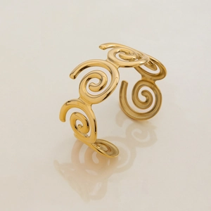 Detailed close-up of golden spiral pattern bracelet with polished stainless steel finish