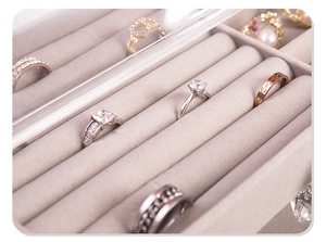 Macro view of velvet ring slots in clear acrylic jewelry box with dustproof lid