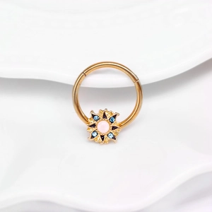 Vue macro d'un anneau de mamelon soleil doré avec perle rose et strass bleus
