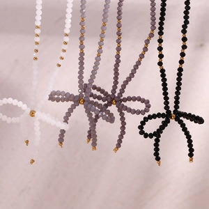 Colliers nœuds papillon faits main en perles noires, blanches et grises avec accents dorés