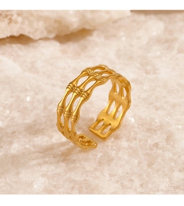 Detail of gold bamboo style adjustable ring displayed on white crystal background