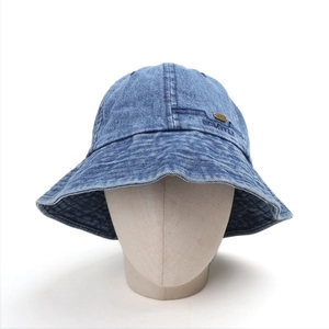 Detail of blue denim bucket hat featuring white letter embroidery and a gold metal logo