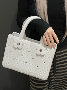 Dettaglio della borsa shopper bianca geometrica con fiori e morbida trama in PU
