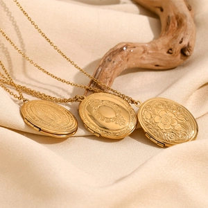 Detailed macro view of vintage 18K gold-plated oval locket necklaces with embossed floral art