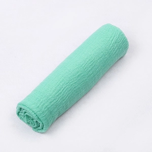 Close-up of green crinkle cotton fabric with soft texture for photography or scarf