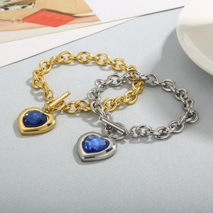 Detailed macro view of heart-shaped blue crystal charms on a chunky OT toggle chain bracelet