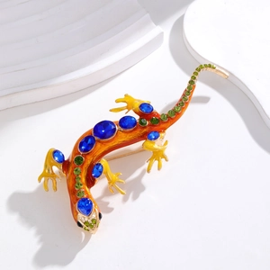 Vue macro détaillée de la broche lézard avec émail orange et cristaux bleus étincelants