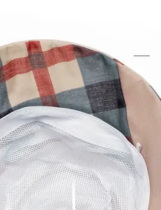 Close-up of breathable mesh lining and cotton sweatband on plaid sun bucket hat