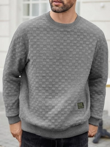 Detail of grey men's waffle knit sweatshirt showing textured checkerboard fabric pattern