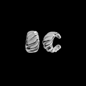 Macro view of silver twisted croissant ear cuffs with a polished mirror finish