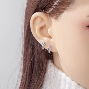 Orecchini a fiocco d'argento con zirconi a cuore azzurro e rosa indossati dal modello