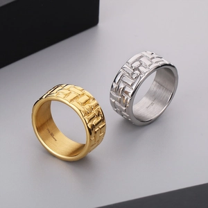 Detail of 316L stainless steel rings featuring woven texture in gold and silver finish