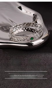 Close-up of silver-plated copper woven lace bracelet with a round green gemstone