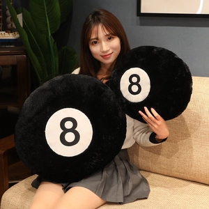 Creative plush No.8 billiard ball cushions in two sizes shown with a model in home setting
