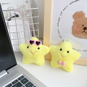 Cute yellow plush star keychain with heart sunglasses and bow on a desk