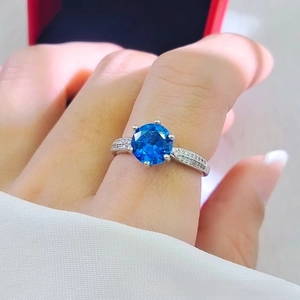 Close-up of elegant 2ct blue sapphire ring featuring classic four-prong setting on hand
