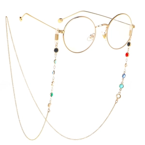 Golden round frame glasses with colorful gemstone eyewear chain on white background