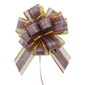 Macro detail of brown and gold checkered ribbon bow with metallic gold trim edges