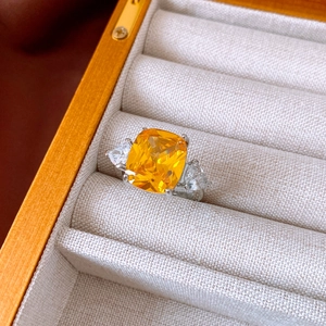 Macro shot of cushion cut yellow zircon ring with side stones in luxury gift box