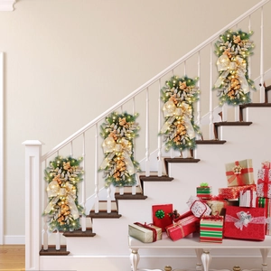 Staircase decorated with four LED Christmas swags featuring gold ribbons and pine cones