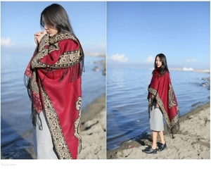 Macro view of thick red cashmere scarf with ethnic paisley patterns and fringe details